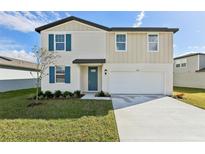 Charming two-story home featuring blue shutters, a well-manicured lawn, and an attached two-car garage at 2122 Rosewood Dr, Bartow, FL 33830