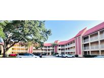 Condominium complex boasts red tile roofs, multiple stories, covered balconies, and ample parking space at 6337 Parc Corniche Dr # 2101, Orlando, FL 32821