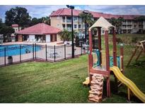 Community playground including a slide, climbing area, and nearby pool provide outdoor fun for residents at 6337 Parc Corniche Dr # 2101, Orlando, FL 32821