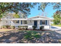Charming home showcasing blue shutters, manicured bushes, and a well-maintained lawn at 211 W Valencia St, Lakeland, FL 33805