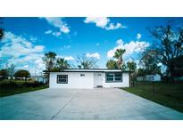 Charming single-story home with white exterior, black trim, and a spacious concrete driveway at 1401 Josephine St, Lakeland, FL 33815