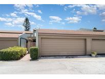 Townhouse featuring a one car garage, brown roof, and manicured landscaping at 2500 21St Nw St # 88, Winter Haven, FL 33881
