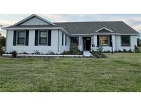 Charming single-story home with white siding, black shutters, and a well-manicured front lawn at 2569 Rogers Rd, Lakeland, FL 33812