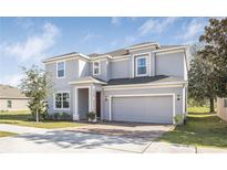 Charming two-story home featuring a brick driveway, a two-car garage and well-maintained landscaping at 3058 Sunscape Ter, Groveland, FL 34736