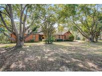 Brick home featuring mature trees and a large front yard at 5670 Sw 34Th St, Ocala, FL 34474