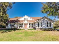 Charming single-Gathering home featuring a well-maintained lawn, rocking chairs, and a welcoming front porch at 725 Giant Oak Rd, Lakeland, FL 33810