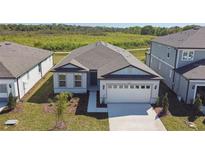 Charming single-story home showcasing a well-maintained lawn and attached two-car garage at 1667 Ruby Ln, Lake Alfred, FL 33850