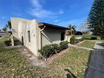 Exterior view of stucco home with landscaping, showing entryway and side yard at 1880 N Crystal Lake Dr # 65, Lakeland, FL 33801