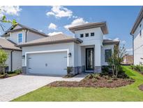 Beautiful single Gathering home with a two-car garage, contemporary design, and landscaped front yard at 7729 Somersworth Dr, Kissimmee, FL 34747