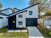 Modern two-story home with a black garage door, well-manicured lawn and geometric walkway at 720 W 14Th St, Lakeland, FL 33805