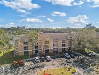 Exterior view of a multi-unit dwelling with assigned parking and some mature landscaping at 8825 Latrec Ave # 6308, Orlando, FL 32819