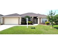 Charming single-story home with a well-manicured lawn, mature trees, and a two-car garage at 524 Buckshot Ln, Lakeland, FL 33809