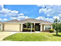 Charming single-story home with a manicured lawn, freshly painted exterior, and attached two car garage at 524 Buckshot Ln, Lakeland, FL 33809