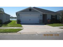 Charming one-story home featuring a two car garage, well-maintained lawn, and traditional design at 1371 Pompay Dr, Davenport, FL 33896