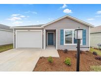 Charming one-story home featuring a one-car garage, blue shutters, landscaped yard, and welcoming front door at 1974 Lockett Ln, The Villages, FL 34762