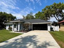 Charming single-story home featuring a well-maintained lawn, attached garage, and manicured flower beds at 858 Lafayette Ln, Lakeland, FL 33805