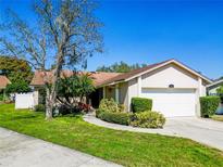 Charming single-story home with a well-manicured lawn, mature tree, and attached two-car garage at 787 Evert Ct, Winter Springs, FL 32708