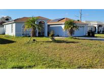 Charming home featuring a well-maintained lawn and mature palm trees, with solar panels discreetly installed at 661 Crane Dr, Kissimmee, FL 34759