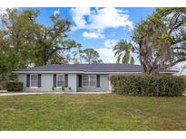 Charming single story home with mature trees and a well-manicured lawn and neatly trimmed shrubbery at 12 Lake Link Dr, Winter Haven, FL 33884