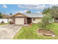 Charming single-story home featuring a brick facade, attached garage, and well-manicured lawn with mature landscaping at 12172 Se 96Th Ter, Belleview, FL 34420