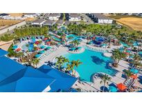 Aerial view of a resort-style pool area with water slides, lounge chairs, and tropical landscaping at 627 Jasmine Ln, Davenport, FL 33897