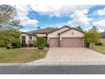 Stunning single-story home with a well-manicured lawn, paver driveway, and a two-car garage at 9761 Sw 74Th Pl, Ocala, FL 34481