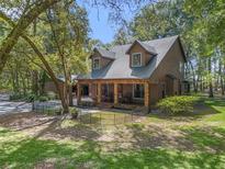 Charming home featuring a covered porch with stone accents and a beautifully landscaped front yard at 4845 Sw 78Th Ave, Bushnell, FL 33513