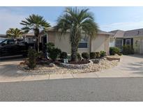 Well-maintained front yard with landscaping and palm trees adding curb appeal to this inviting home at 3105 Carrollton Ct, The Villages, FL 32162