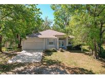 Charming single-story home featuring a well-manicured lawn, mature trees, and a cozy facade at 2920 Ewell Rd, Lakeland, FL 33811