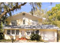 Charming two-story home featuring a well-maintained yard, attached garage, and traditional architectural details at 114 1St Nw St, Fort Meade, FL 33841