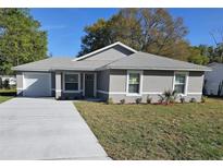 Charming single-story home featuring a well-maintained lawn and a long concrete driveway at 716 Byni Rdg, Winter Haven, FL 33880