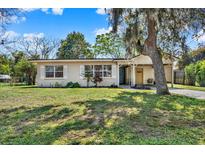 Charming single-story home with a well-maintained lawn and mature shade tree at 2421 Cypress Ln, Lakeland, FL 33801