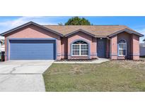 Charming single-story home featuring a large front lawn and a two-car garage at 3312 Sangria Pass, Lakeland, FL 33811