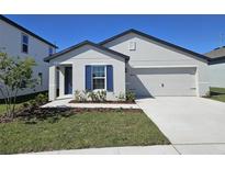 Charming single-Gathering home with a freshly landscaped yard, an attached two-car garage and dark blue door and shutters at 1649 Nantucket Way, Winter Haven, FL 33884