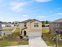 Two-story home with a manicured lawn, fresh landscaping, and a two-car garage at 1773 Yellow Trl, Lakeland, FL 33801