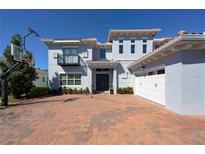 Stunning home featuring a balcony, a three car garage and a basketball hoop over a brick driveway at 108 Stanton Estates Cir, Winter Garden, FL 34787