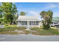 Charming single Gathering home featuring a welcoming front porch and mature trees at 215 Maple Ln, Fort Meade, FL 33841