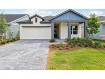 Charming single-story home with a beautifully landscaped front yard and a brick driveway at 6057 Sacred Oak Ave, Mount Dora, FL 32757