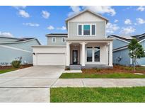 Inviting two-story home with modern design, manicured lawn, attached garage, and covered front porch at 3092 Expedition Dr, St Cloud, FL 34771