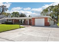 Charming brick home with a well-manicured front yard, a driveway, and an attached garage, showcasing curb appeal at 1841 5Th Se St, Winter Haven, FL 33880