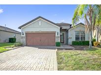 Charming single-story home with a paver driveway, two-car garage, and well-maintained landscaping at 474 Del Sol Ave, Davenport, FL 33837