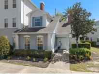 Charming two-story home featuring manicured landscaping, a brick chimney, and a welcoming front entrance at 7636 Heritage Crossing Way, Reunion, FL 34747