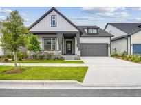 Charming home with gray trim, stone accents, a well-manicured lawn, and an attached two-car garage at 6615 Quest St, St Cloud, FL 34771