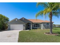 Charming single-story home with a well-manicured lawn and a mature palm tree, offers a welcoming curb appeal at 1112 View Pointe Cir, Lake Wales, FL 33853