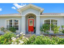 Charming home featuring a vibrant red door and well-maintained landscaping, creating an inviting entrance at 3548 Galloway Oaks Ct, Lakeland, FL 33810