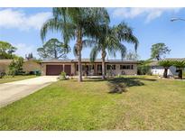 Charming single-story home featuring a well-manicured lawn and mature palm trees, creating a welcoming curb appeal at 1062 Mayflower Ave, Deltona, FL 32725