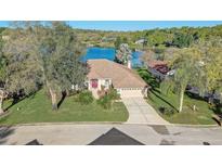 Charming home on a lush green lot with lake views and mature trees and landscaping at 10837 Versailles Blvd, Clermont, FL 34711