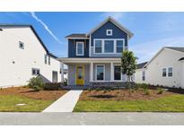 Charming two-story home with blue and gray accents, a welcoming front porch and professionally landscaped front yard at 3083 Voyager Ave, St Cloud, FL 34771