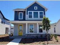 Charming two-story home featuring a bright yellow door and a welcoming covered front porch at 3083 Voyager Ave, St Cloud, FL 34771