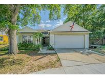 Charming single-story home featuring an attached garage, mature trees, and appealing landscaping at 6125 Morningdale Ave, Lakeland, FL 33813